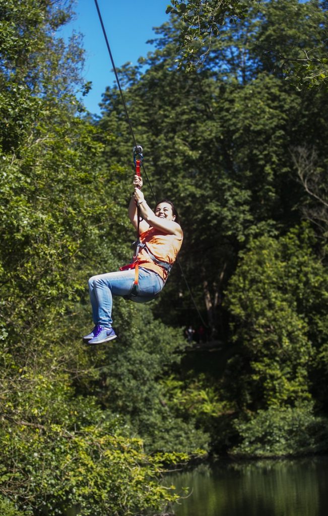 Mujer utilizando una tirolina en una actividad de turismo activo en Asturias