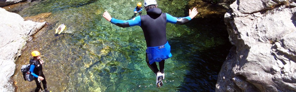 Persona saltando a una poza haciendo barranquismo o descenso de barrancos